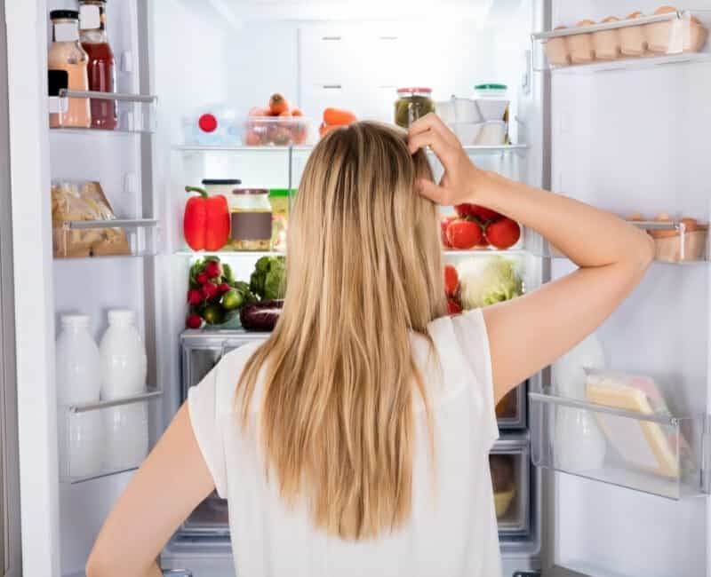 Declutter before a move - woman looking in fridge