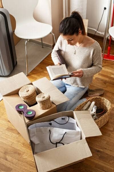 How to declutter before a move - girl packing boxes