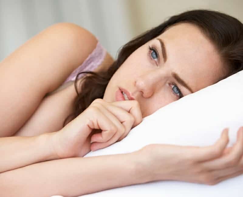 Things that waste your time: woman lying in bed worrying
