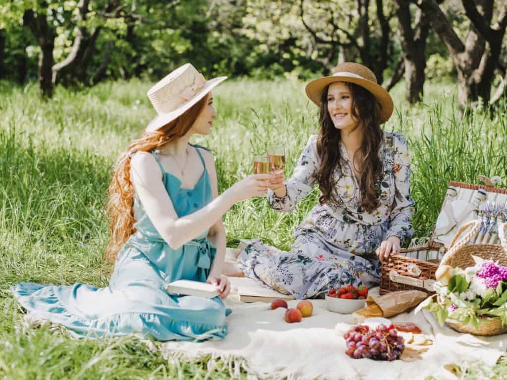 Two women having a picnic outside on the grass