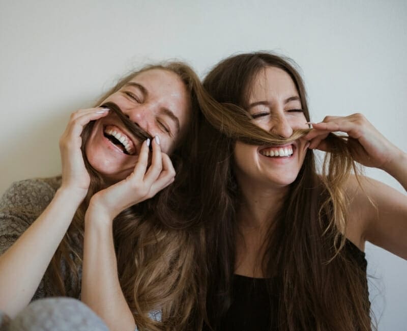 Mental Minimalism: two women making faces and playing with their hair