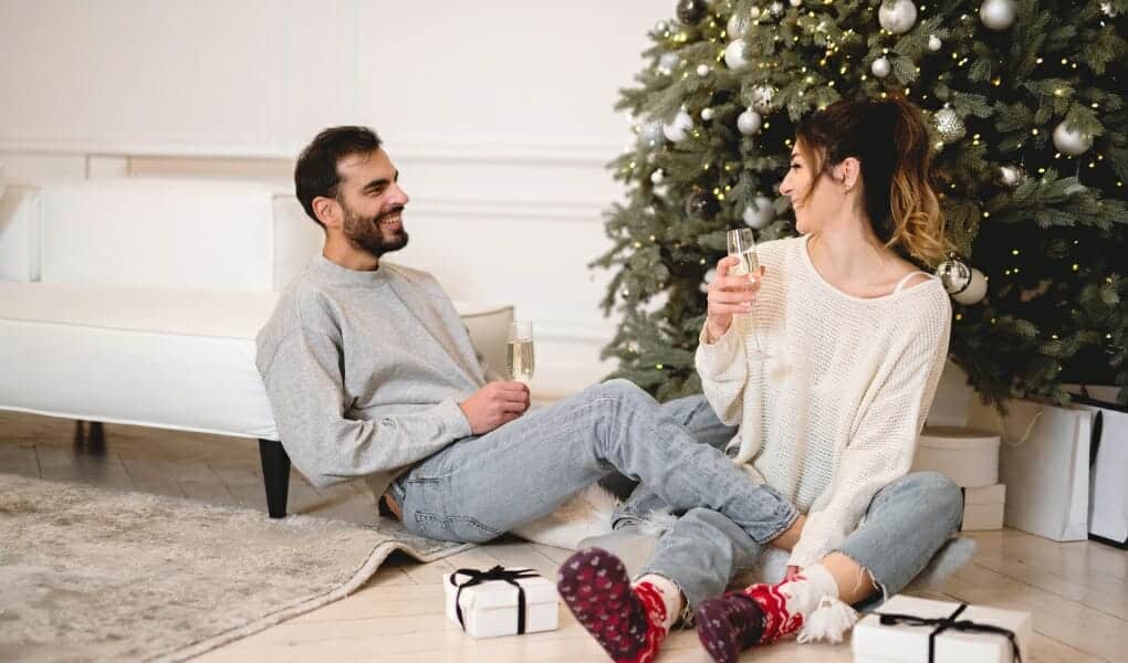 Decluttering-before-Christmas-couple-having-wine-next-to-the-Christmas-tree