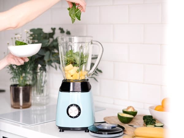 Woman making a healthy smoothie in a blender