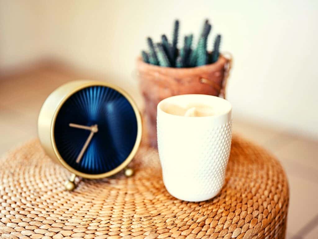 Declutter your mind: A clock and cup of coffee on a wicker table