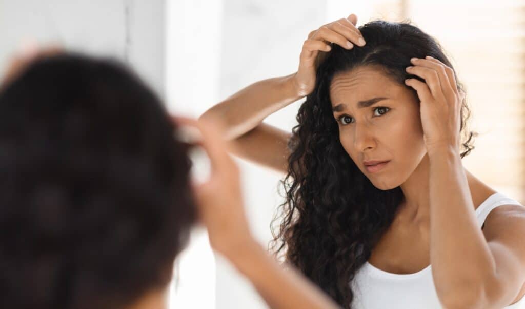 Woman unhappily looking in mirror